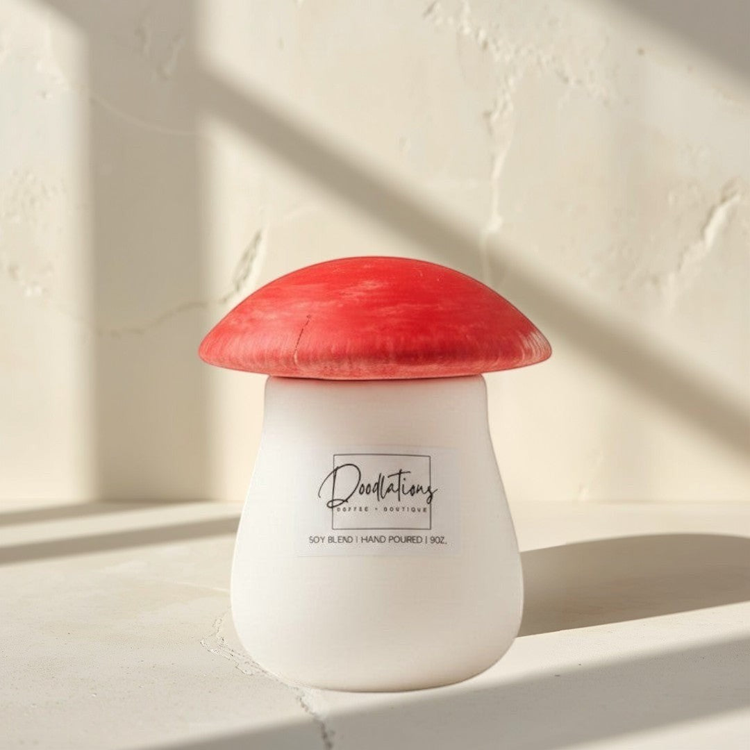 Doodlations Coffee Bar & Boutique mushroom-shaped concrete candle with a red cap and white base, soy blend wax, salted honey scent.
