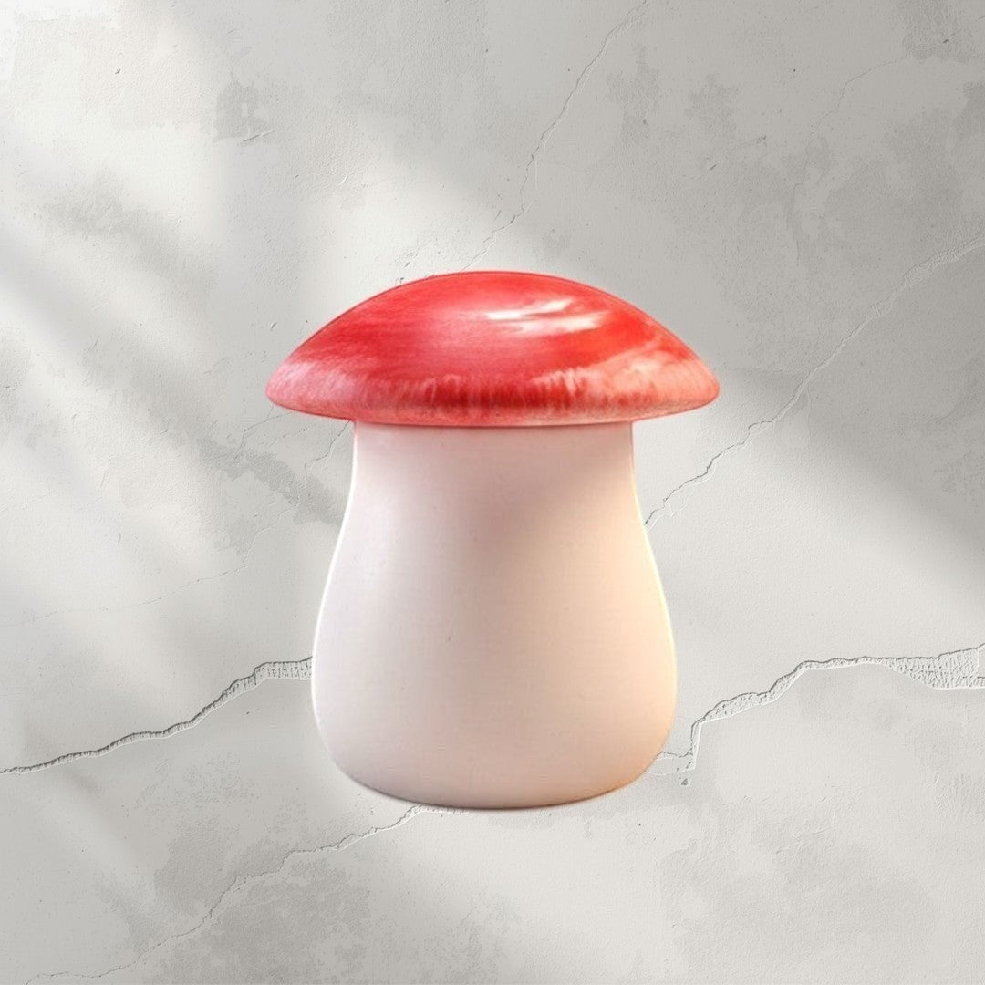 Doodlations Coffee Bar & Boutique mushroom-shaped concrete candle in pale pink with a glossy red top, Salted Honey scent.