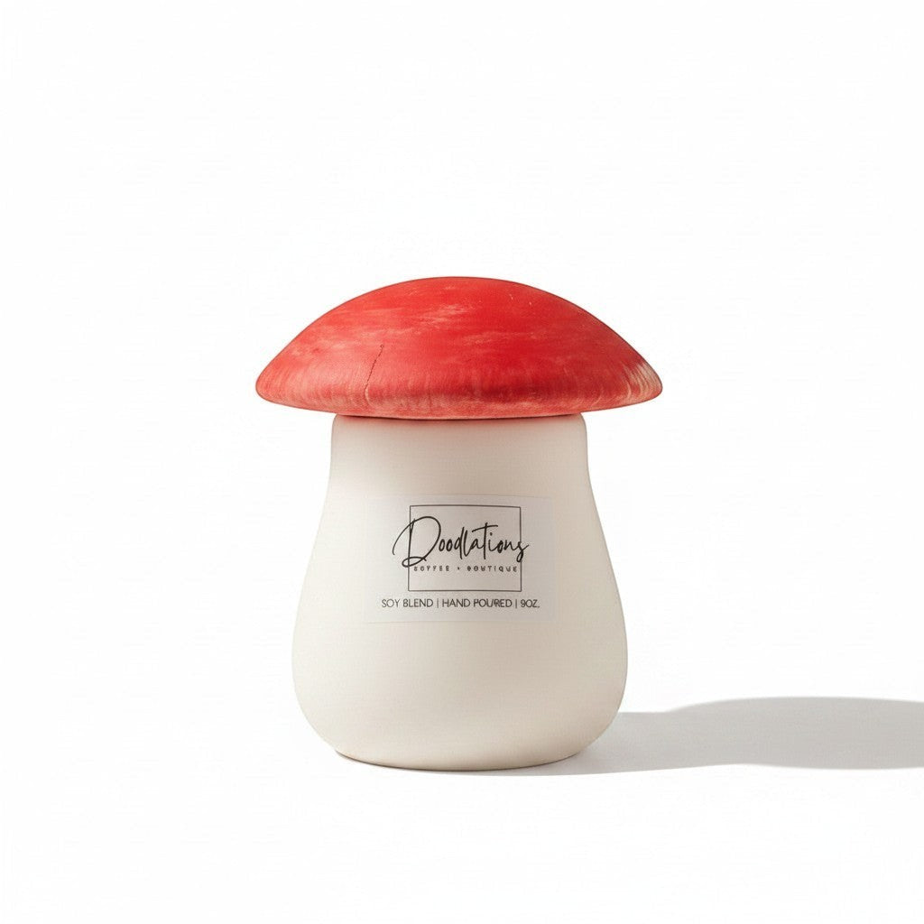Doodlations Coffee Bar & Boutique mushroom-shaped concrete candle with a red cap and white base, filled with soy blend wax.