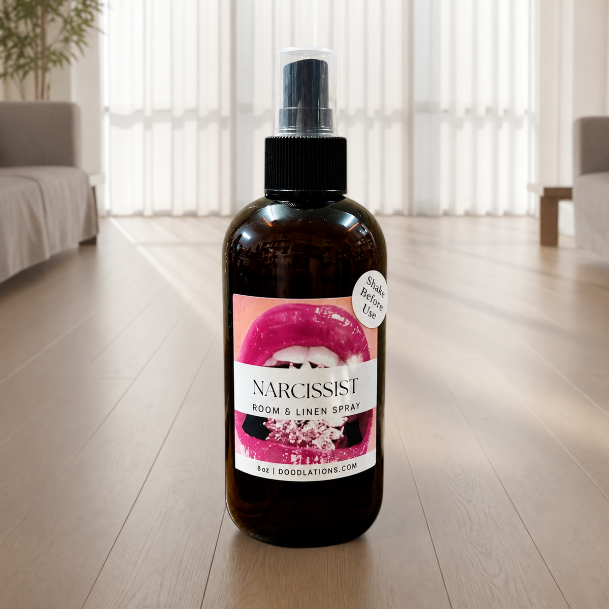Doodlations Coffee Bar & Boutique Narcissist room and linen spray in an amber glass bottle with a pink lips label.