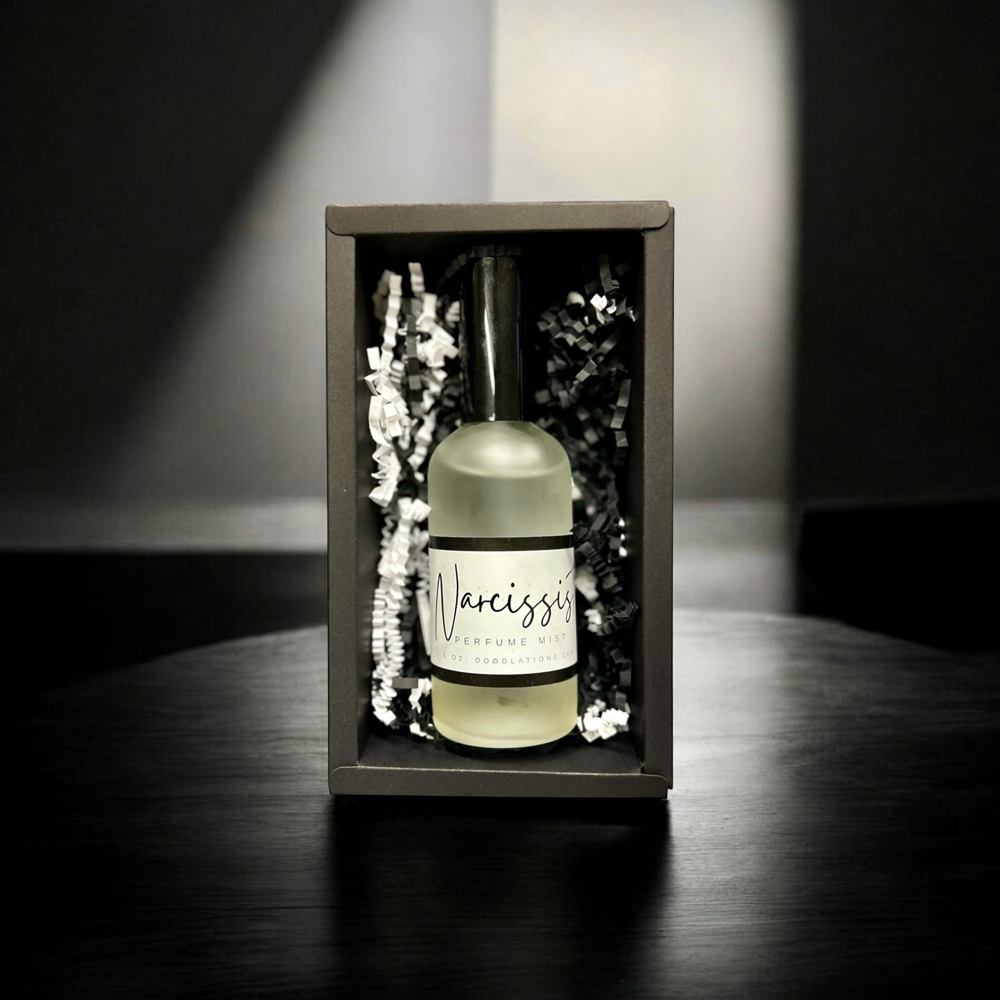 Doodlations Coffee Bar & Boutique The Narcissist luxury fine mist perfume in a black gift box with shredded paper.