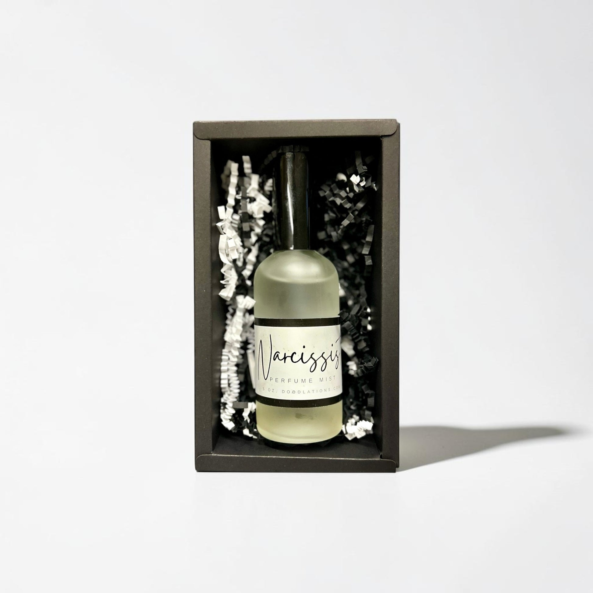 Doodlations Coffee Bar & Boutique The Narcissist luxury fine mist perfume in a black gift box with paper filler.