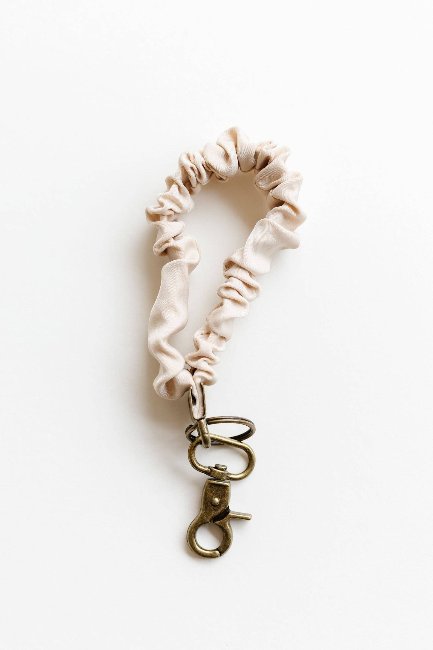 Doodlations Coffee Bar & Boutique oat milk luxe fabric scrunchie keychain with a bronze metal clasp.