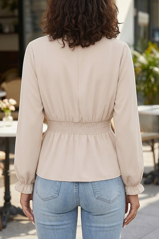 Back view of Doodlations Coffee Bar & Boutique oatmeal long sleeve blouse with cinched elastic waist and ruffled cuffs