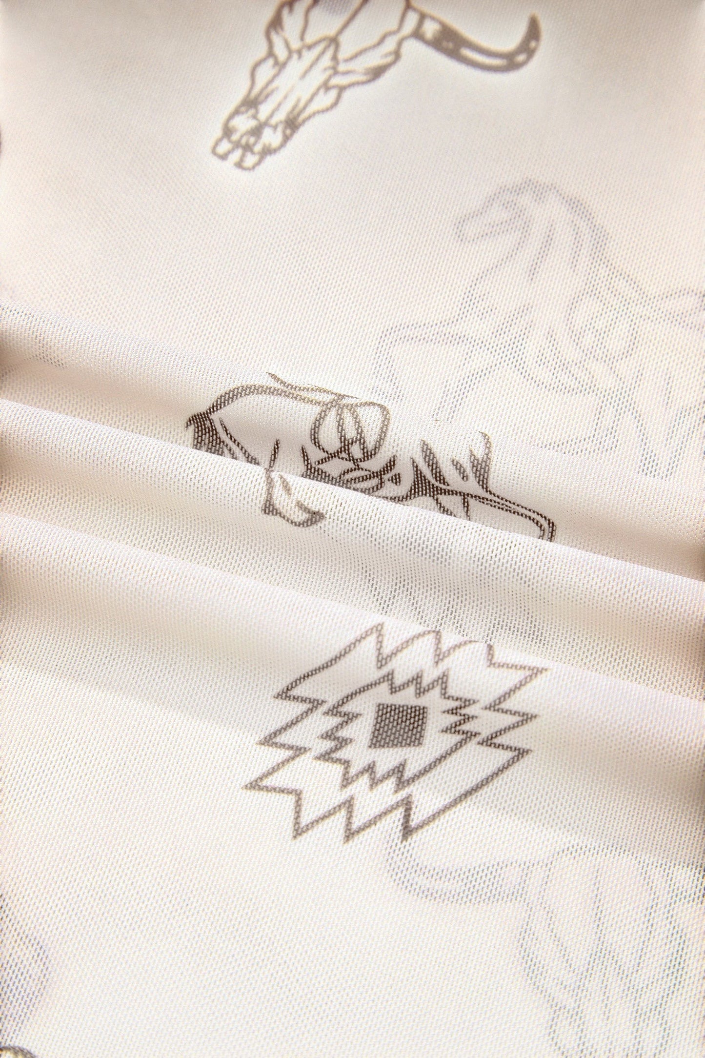 Doodlations Coffee Bar & Boutique oatmeal mesh long sleeve top with detailed Western-inspired skull and geometric print