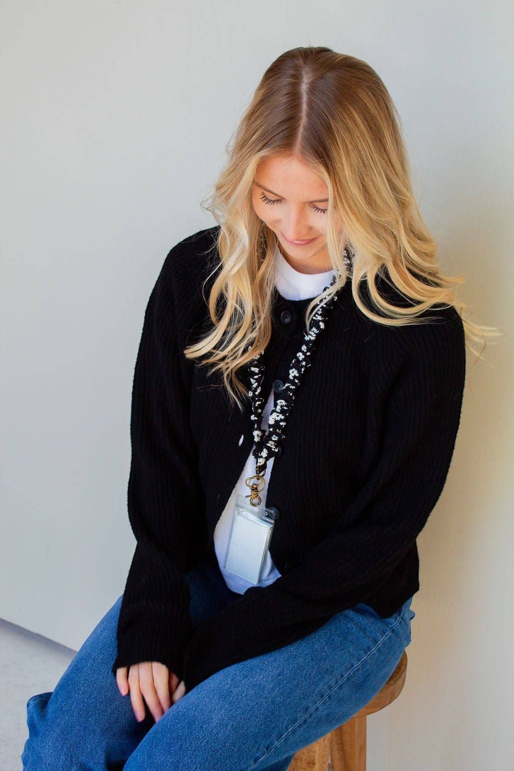 Doodlations Coffee Bar & Boutique black and white floral polyester lanyard worn by a woman in a black cardigan
