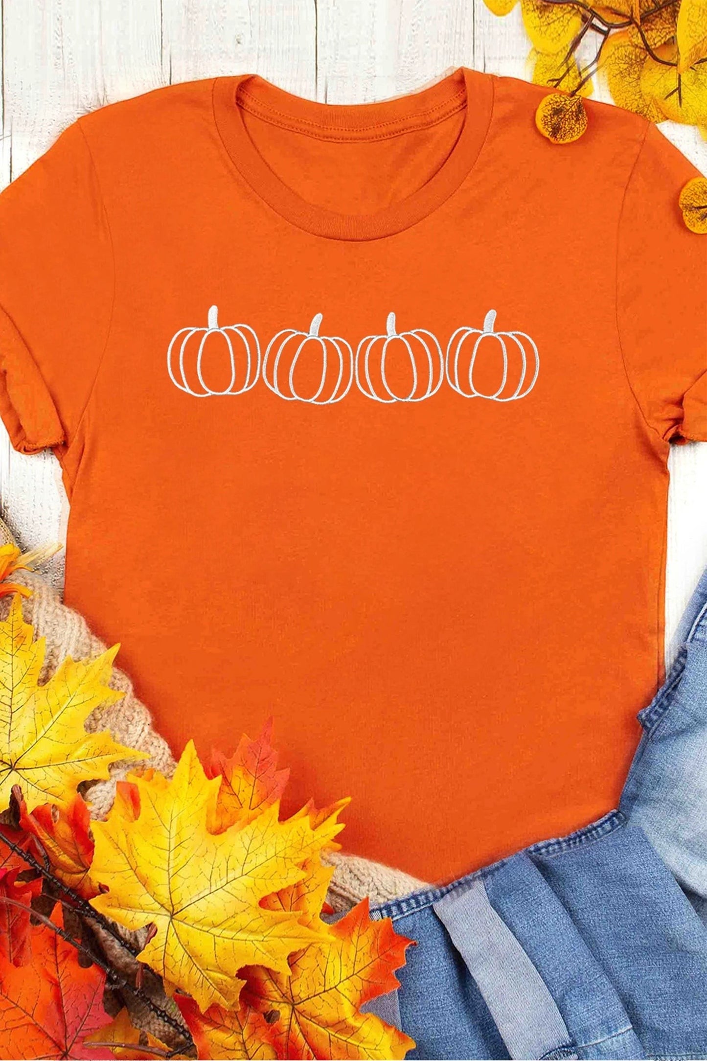 Doodlations Coffee Bar & Boutique orange t-shirt with white embroidered pumpkin design and round neck