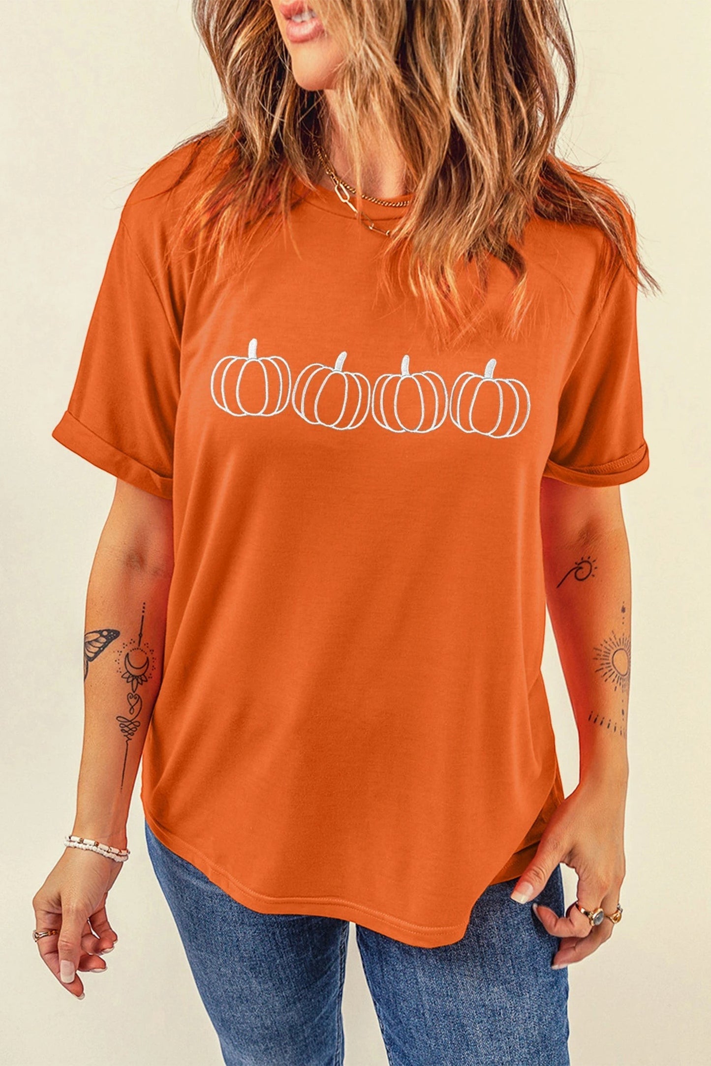 Doodlations Coffee Bar & Boutique orange t-shirt with white embroidered pumpkin design and round neck
