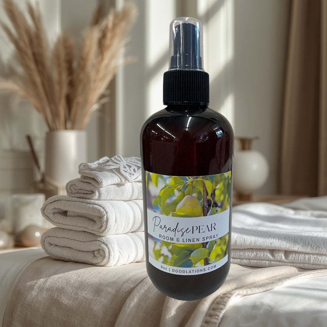 Doodlations Coffee Bar & Boutique Paradise Pear room and linen spray in a dark amber bottle with a spray nozzle.