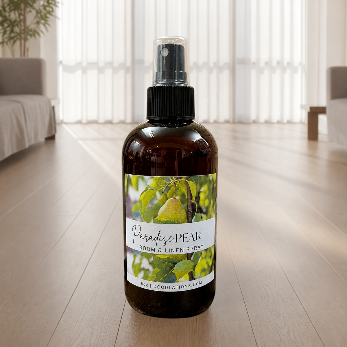 Doodlations Coffee Bar & Boutique Paradise Pear room and linen spray in an amber glass bottle on a wooden floor.
