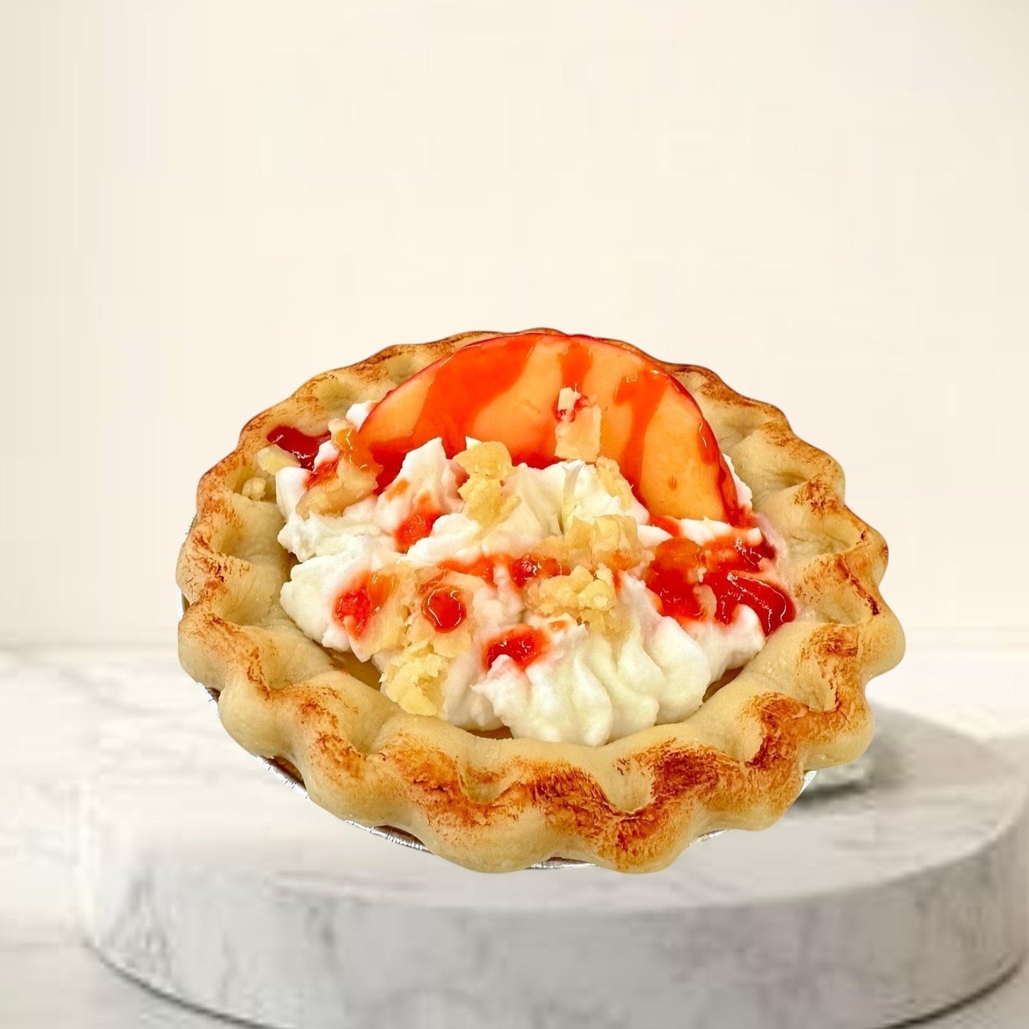 Doodlations Coffee Bar & Boutique Peach Pie candle designed to look like a real pie with whipped cream and fruit topping.