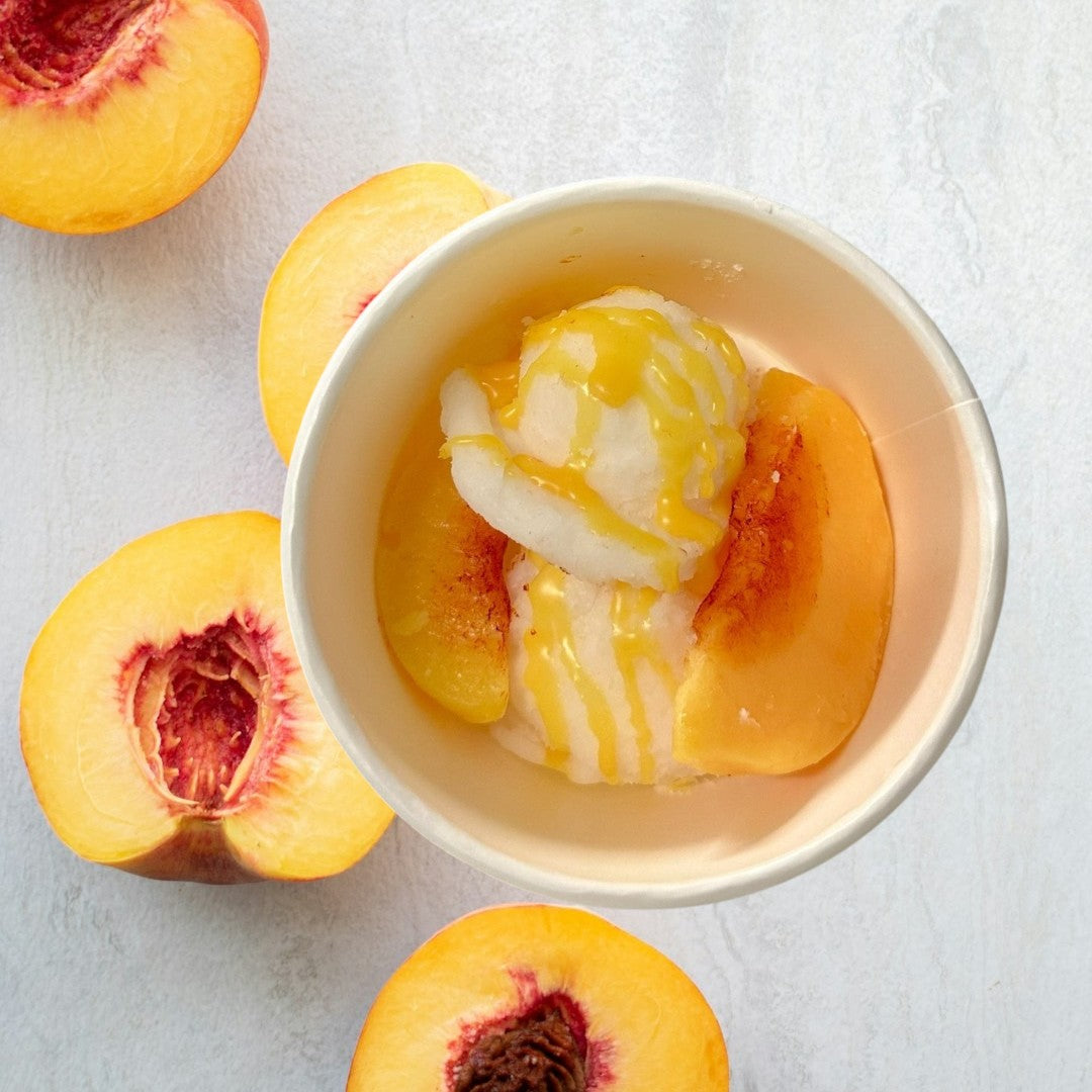 Doodlations Coffee Bar & Boutique Peaches and Cream wax melts shaped like ice cream with peach slices and syrup.