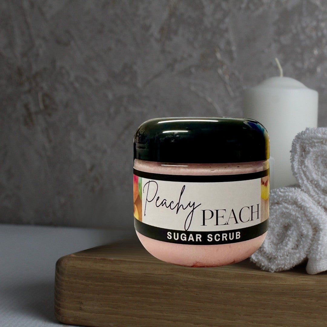 Doodlations Coffee Bar & Boutique Peachy Peach sugar scrub in a clear jar with a black lid. Pink scrub with peach imagery.
