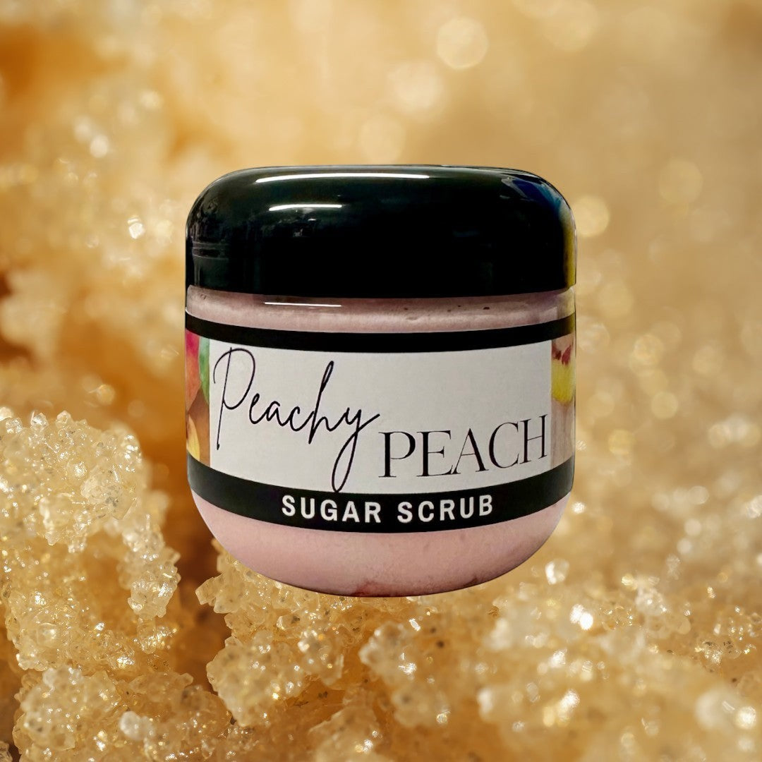 Doodlations Coffee Bar & Boutique Peachy Peach sugar scrub in a clear jar with a black lid. Pink scrub with peach imagery.
