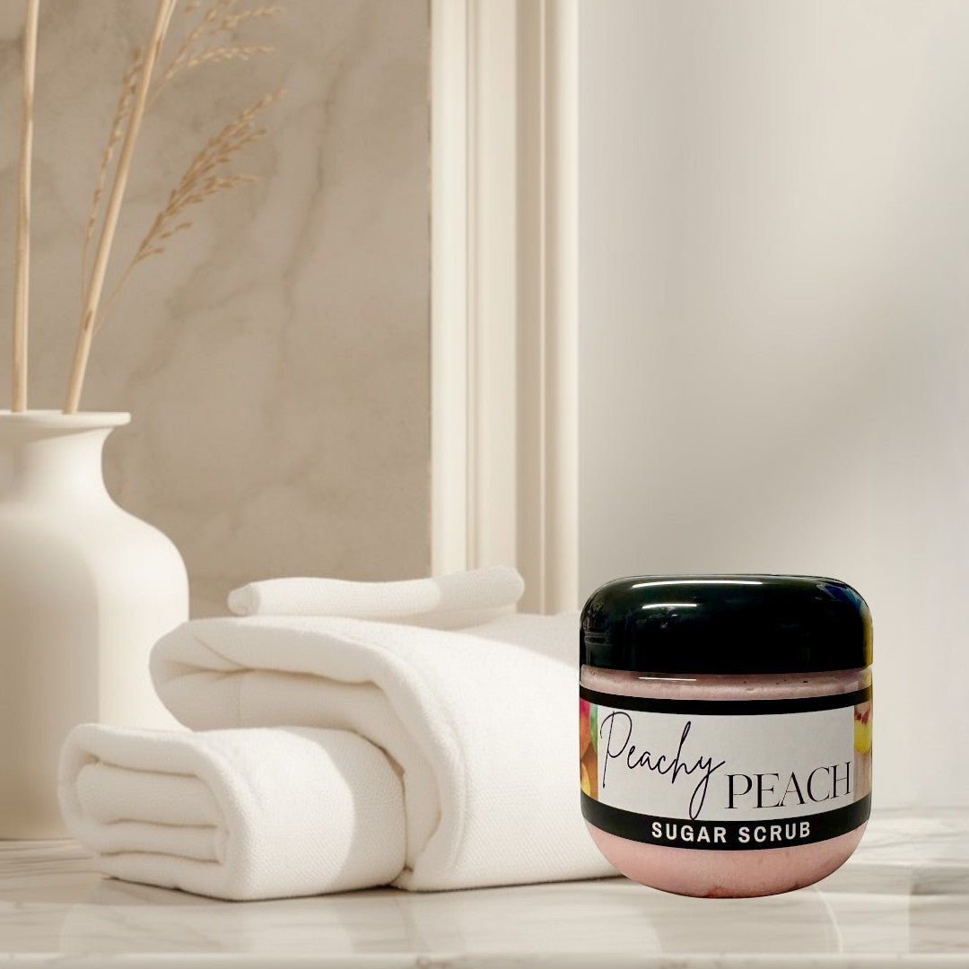 Doodlations Coffee Bar & Boutique Peachy Peach sugar scrub in a clear jar with a black lid. Pink scrub with peach imagery.