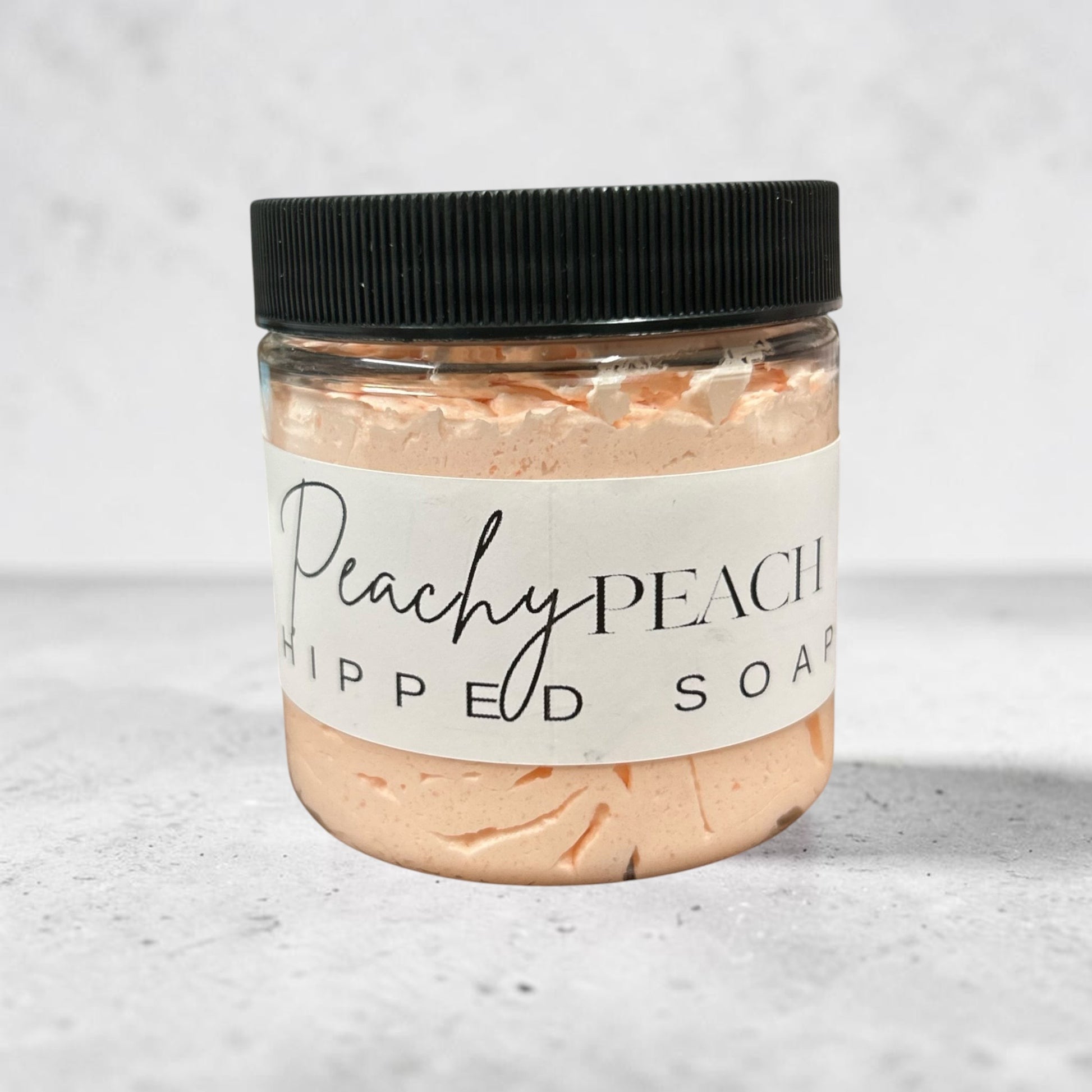 Doodlations Coffee Bar & Boutique Peachy Peach whipped soap in a 4 oz clear jar with a black lid.