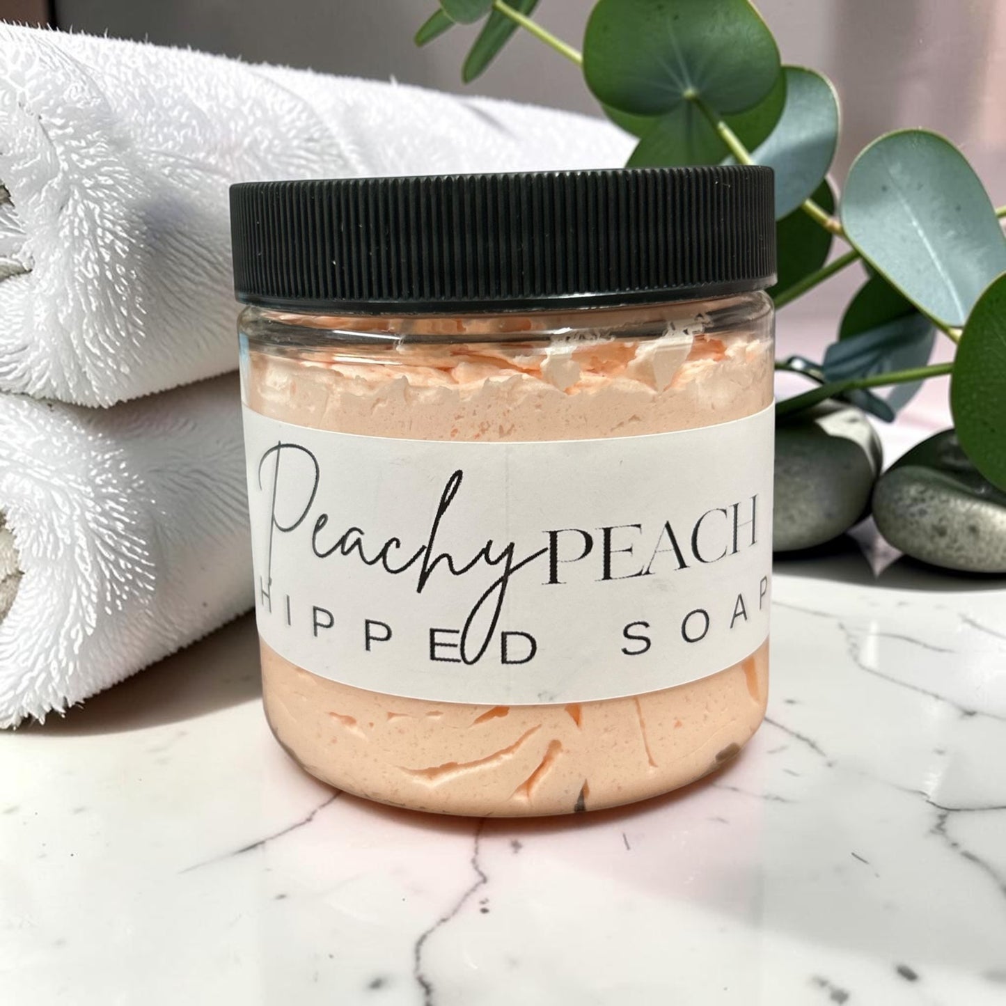 Doodlations Coffee Bar & Boutique Peachy Peach whipped soap in a 4oz jar with a black lid and peach-colored cream.