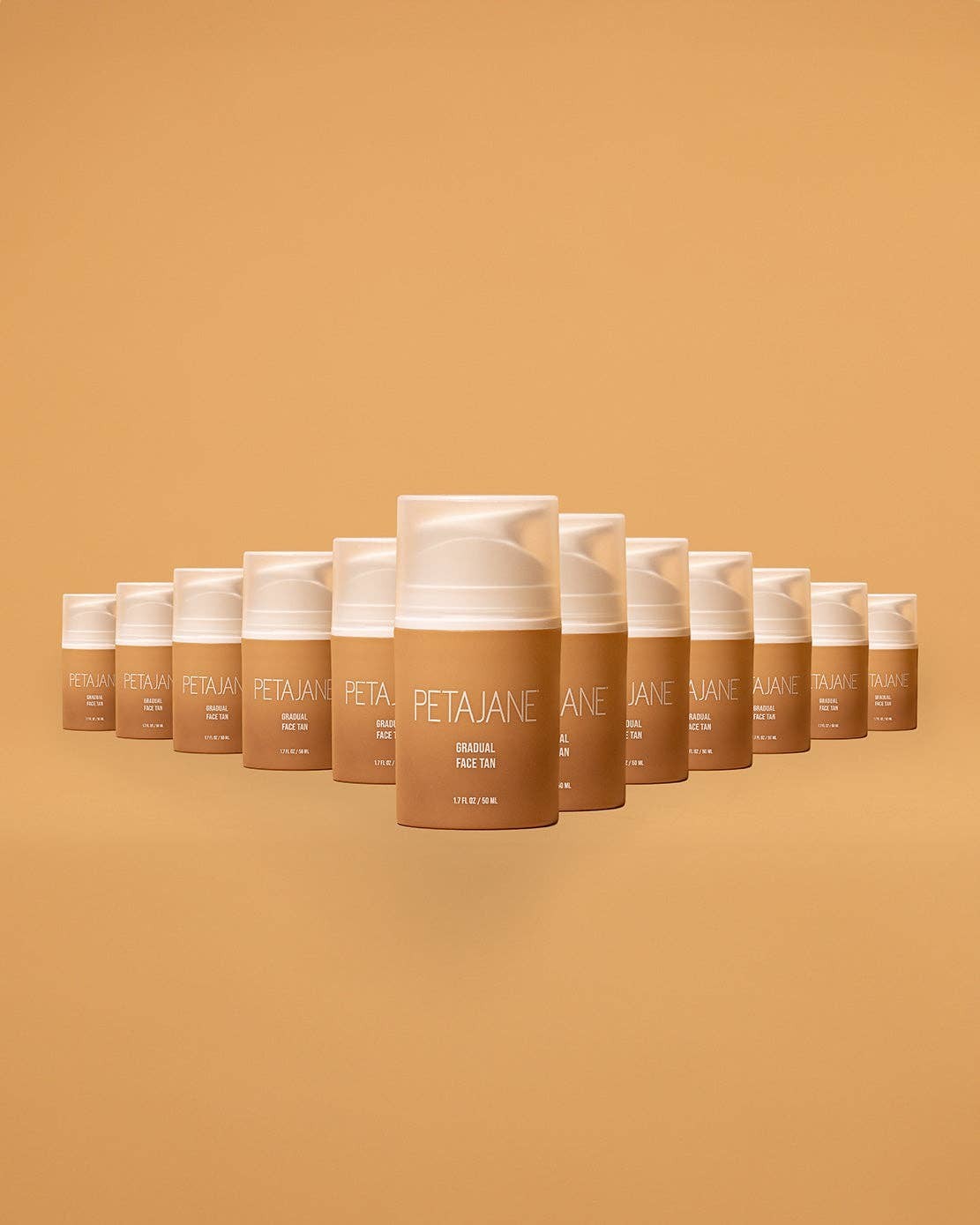 Doodlations Coffee Bar & Boutique Petajane Gradual Face Tan bottles arranged in a triangle on a tan background.
