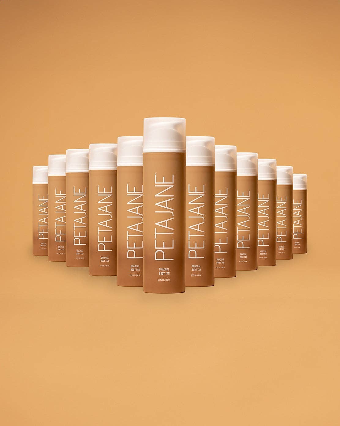 Doodlations Coffee Bar & Boutique Petajane Gradual Body Tan bottles arranged in a pyramid on a tan background.