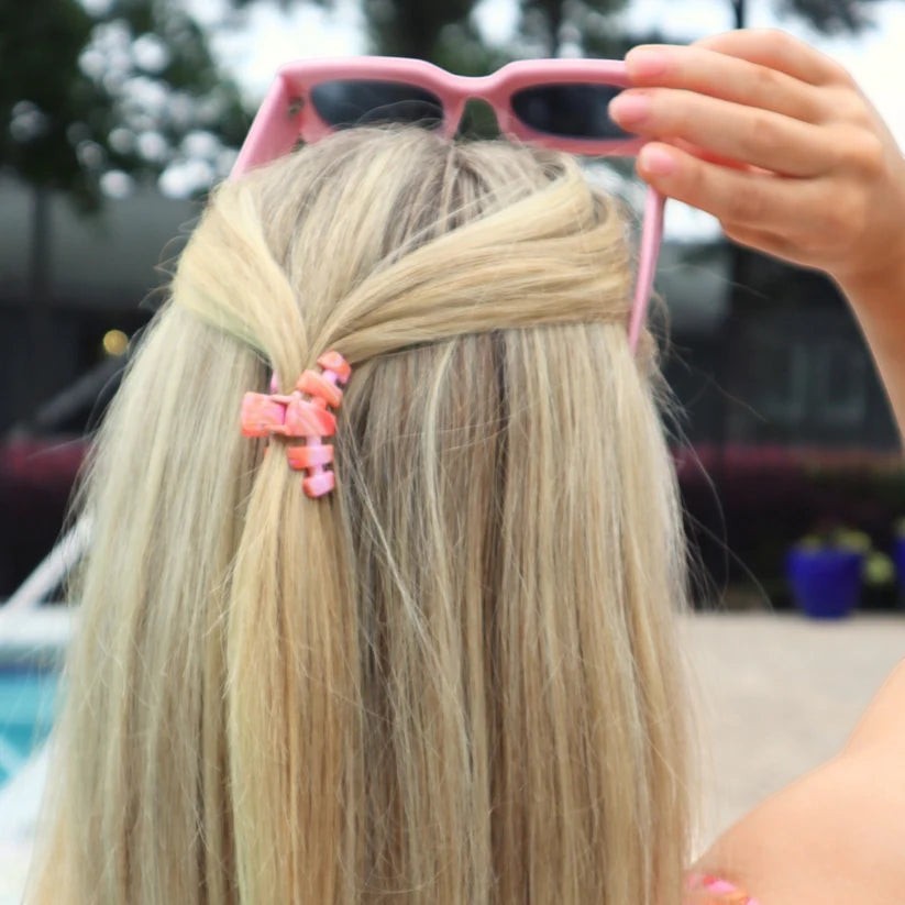 Doodlations Coffee Bar & Boutique Classic Just Keep Swimming claw clip in pink holding blonde hair in a half-up style