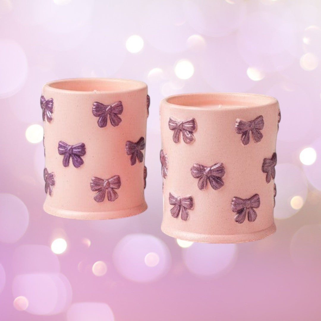 Doodlations Coffee Bar & Boutique pink concrete candle with purple bow accents, soy blend wax, Tipsy Berry Cherry scent.