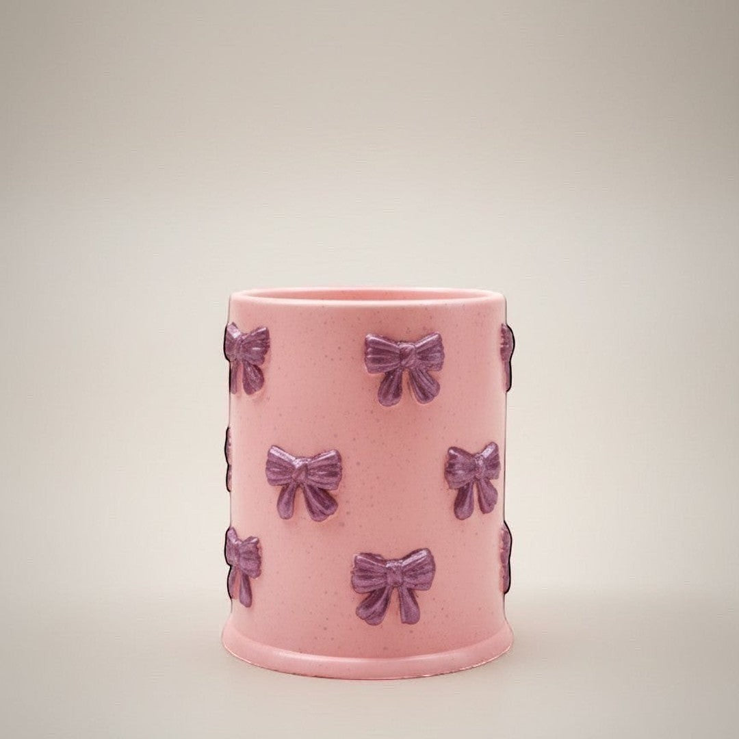 Doodlations Coffee Bar & Boutique pink concrete candle with purple bow accents, 8oz soy blend wax, Tipsy Berry Cherry scent.