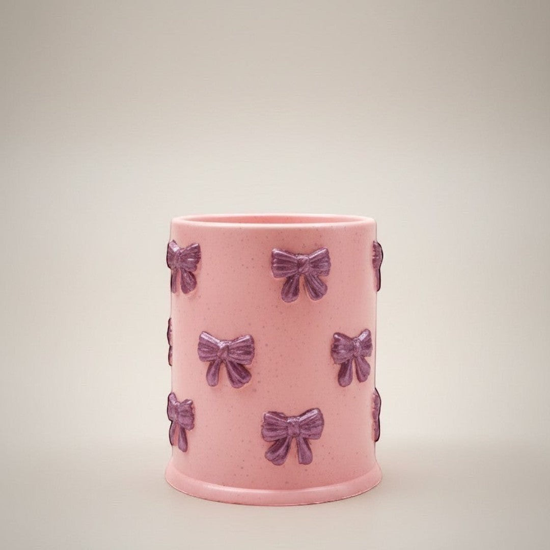 Doodlations Coffee Bar & Boutique pink concrete candle with purple bow accents, 8oz soy blend wax, Tipsy Berry Cherry scent.