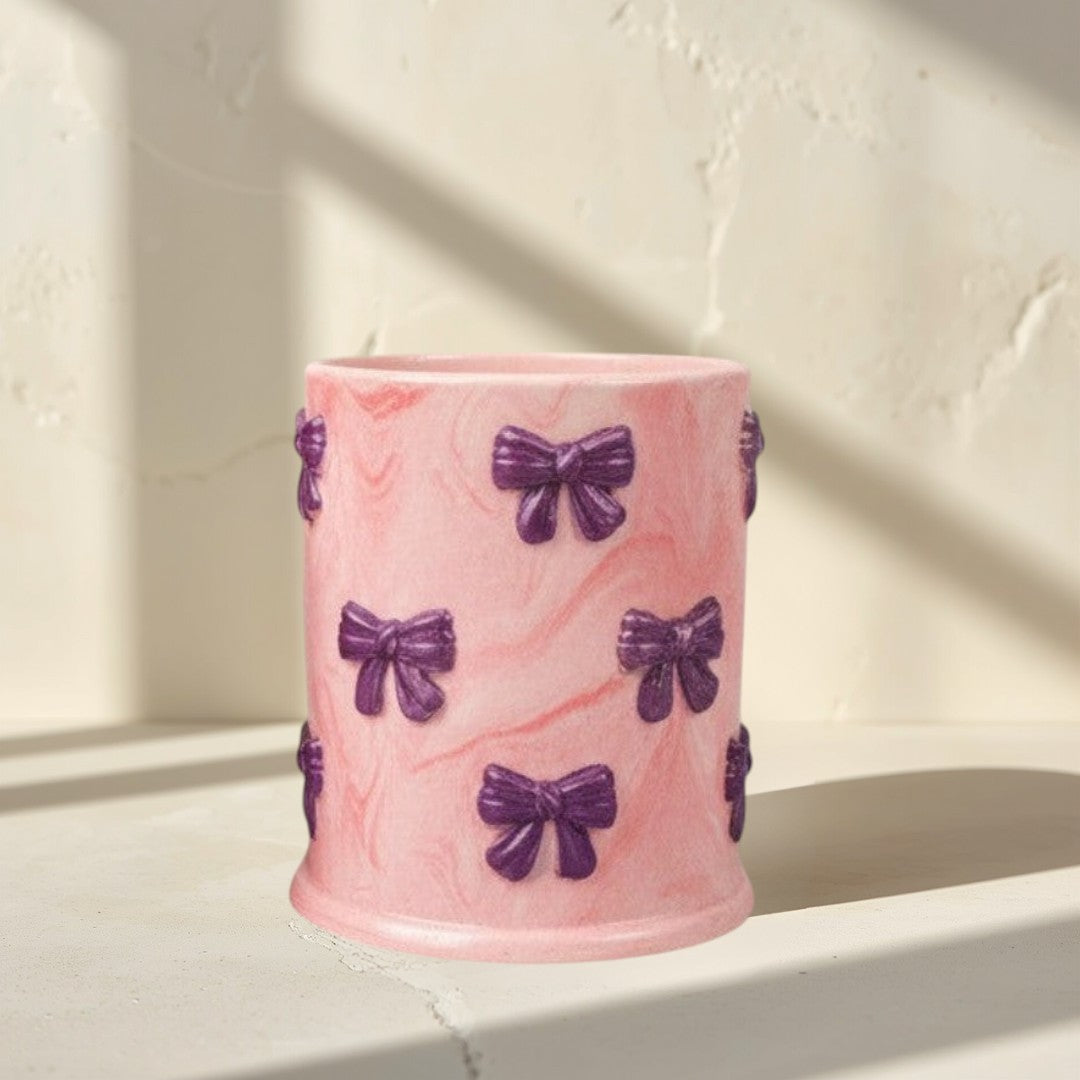 Doodlations Coffee Bar & Boutique pink concrete candle with purple bow accents and soy blend wax. Tipsy Berry Cherry scent.