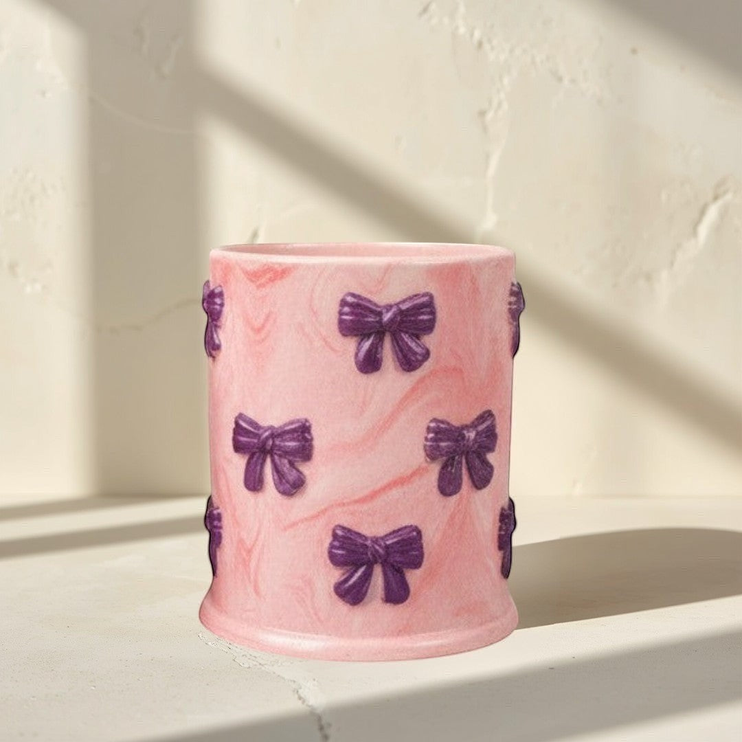Doodlations Coffee Bar & Boutique pink concrete candle with purple bow accents and soy blend wax. Tipsy Berry Cherry scent.