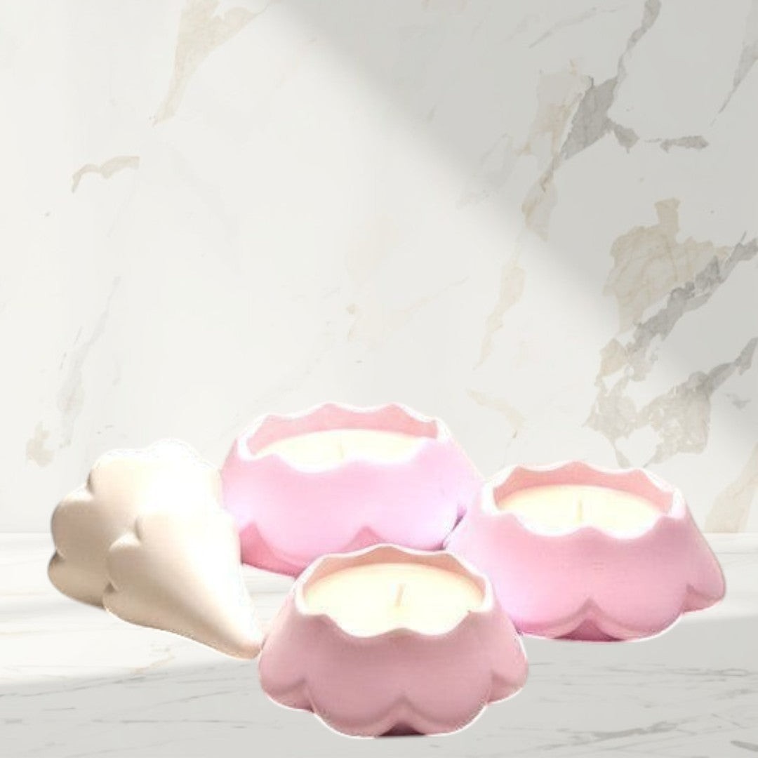 Doodlations Coffee Bar & Boutique pink scalloped concrete candles and a white decorative cone on a grey background.