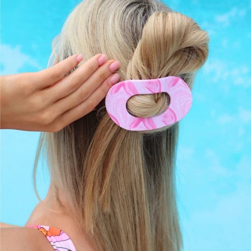 Doodlations Coffee Bar & Boutique pink marble flat round hair clip worn by a woman with blonde hair by a pool