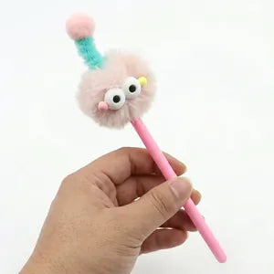 Doodlations Coffee Bar & Boutique pink gel pen with a fuzzy monster topper featuring big eyes and a playful antenna.