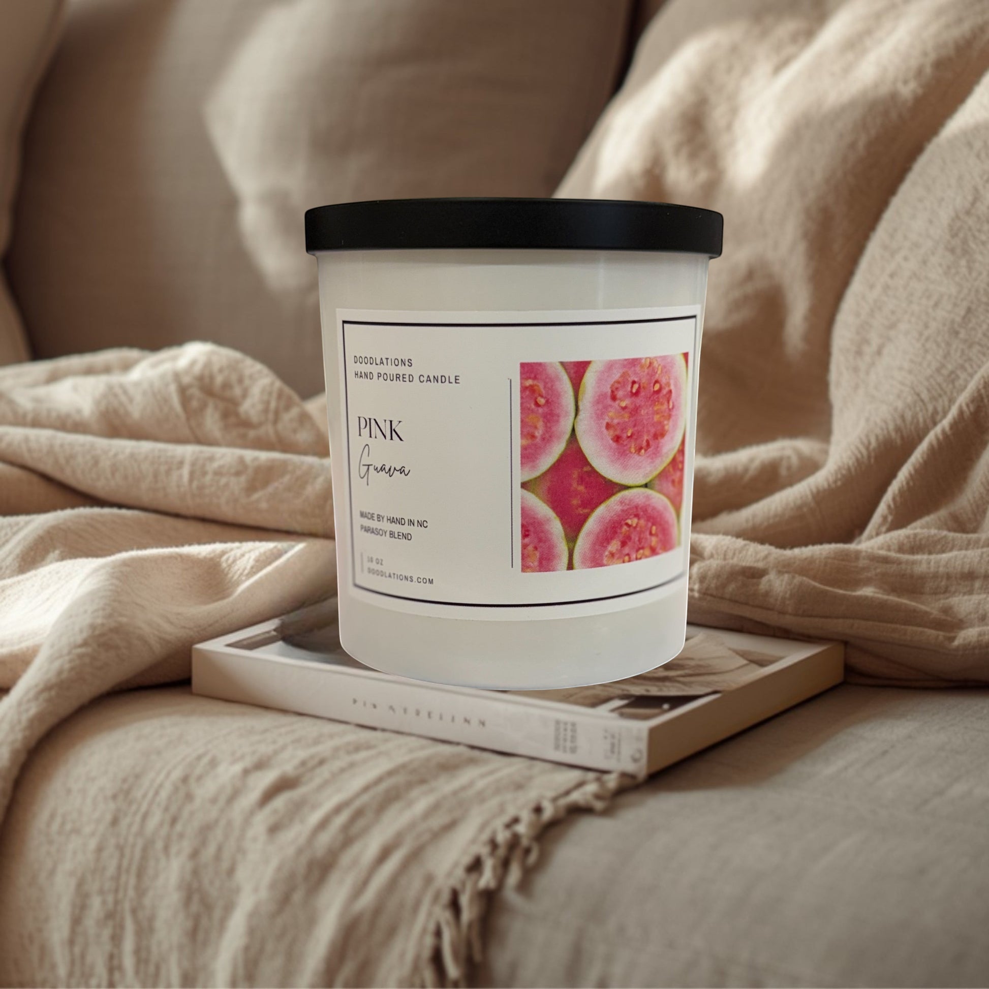 Doodlations Coffee Bar & Boutique Pink Guava hand-poured soy blend candle with a tropical beach background.