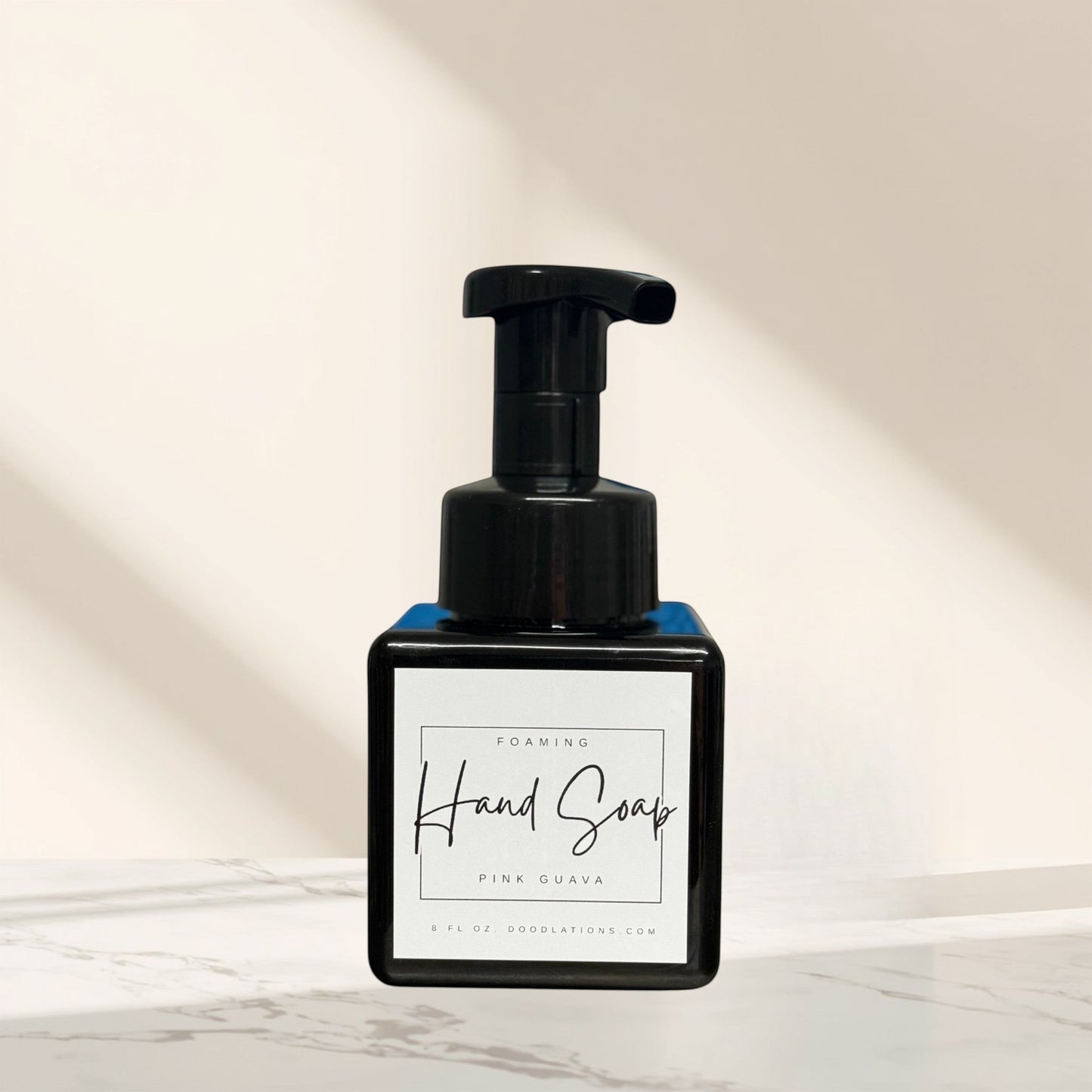 Doodlations Coffee Bar & Boutique Pink Guava foaming hand soap in a black square bottle with a black pump dispenser.