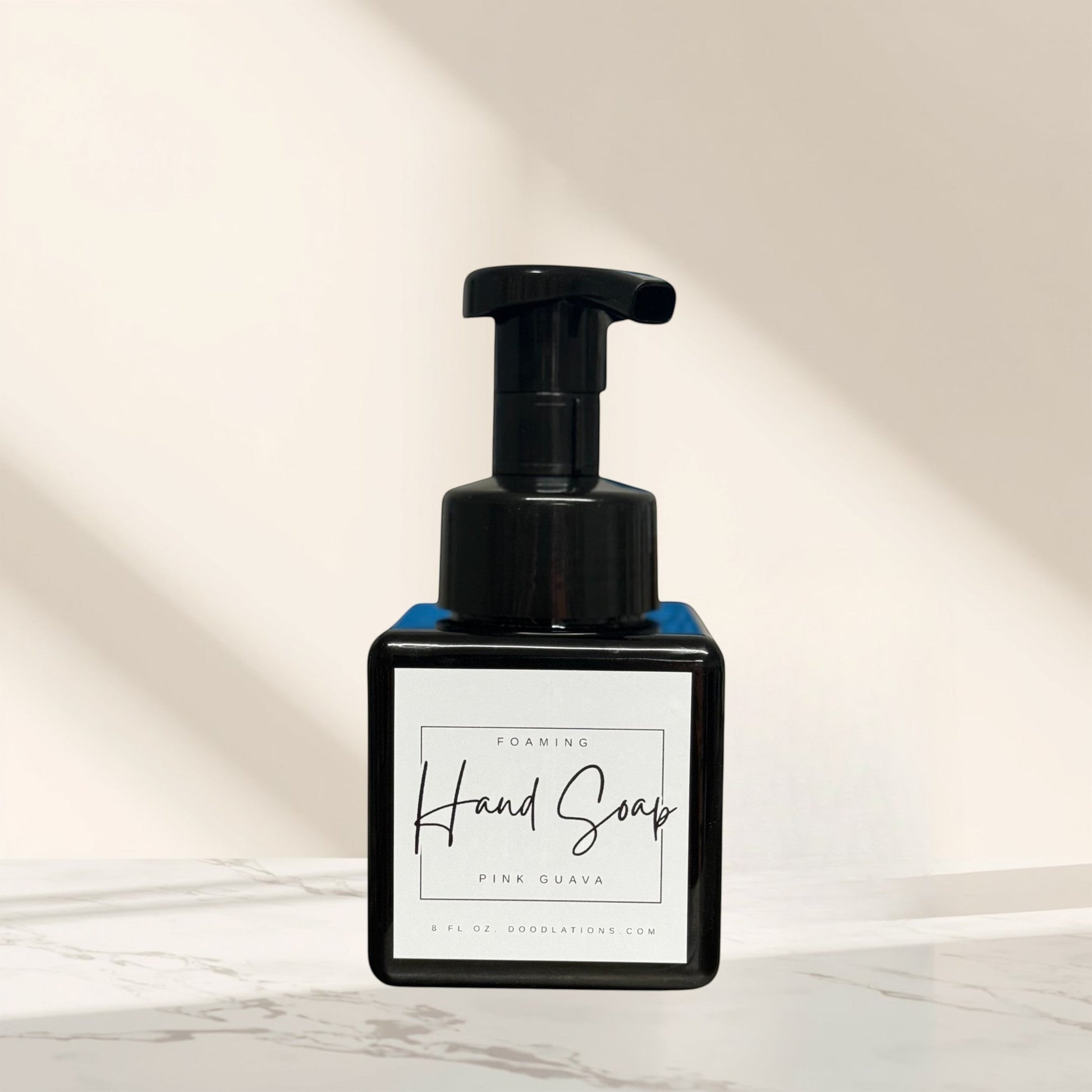 Doodlations Coffee Bar & Boutique Pink Guava foaming hand soap in a black square bottle with a black pump dispenser.