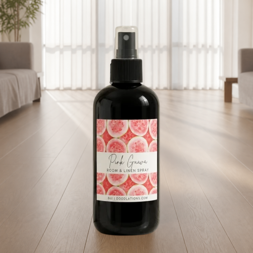 Doodlations Coffee Bar & Boutique Pink Guava room and linen spray in a black bottle with a tropical fruit label.
