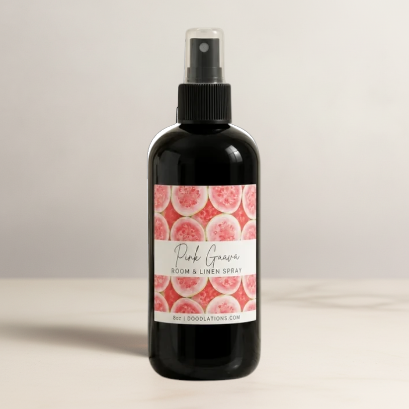 Doodlations Coffee Bar & Boutique Pink Guava room and linen spray in a black bottle with a tropical fruit label.