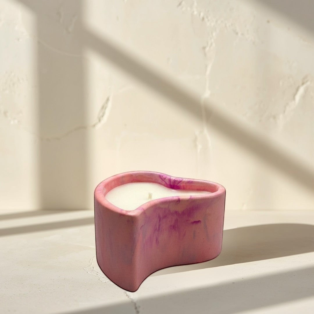 Doodlations Coffee Bar & Boutique hand-poured pink marbled concrete heart-shaped candle with white wax.