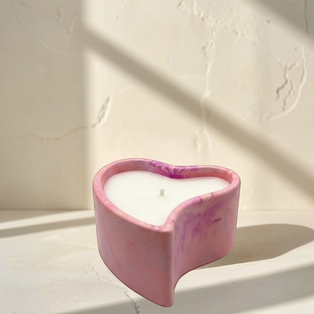 Doodlations Coffee Bar & Boutique hand-poured pink marbled concrete heart candle with white wax.