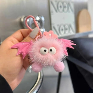 Doodlations Coffee Bar & Boutique pink plush bat bag charm with googly eyes and wings on a metal clasp