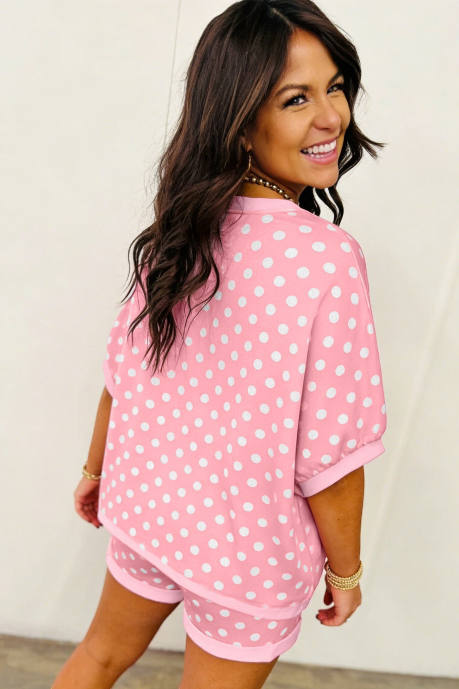 Doodlations Coffee Bar & Boutique pink and white polka dot lounge set with short sleeves and shorts on a smiling woman