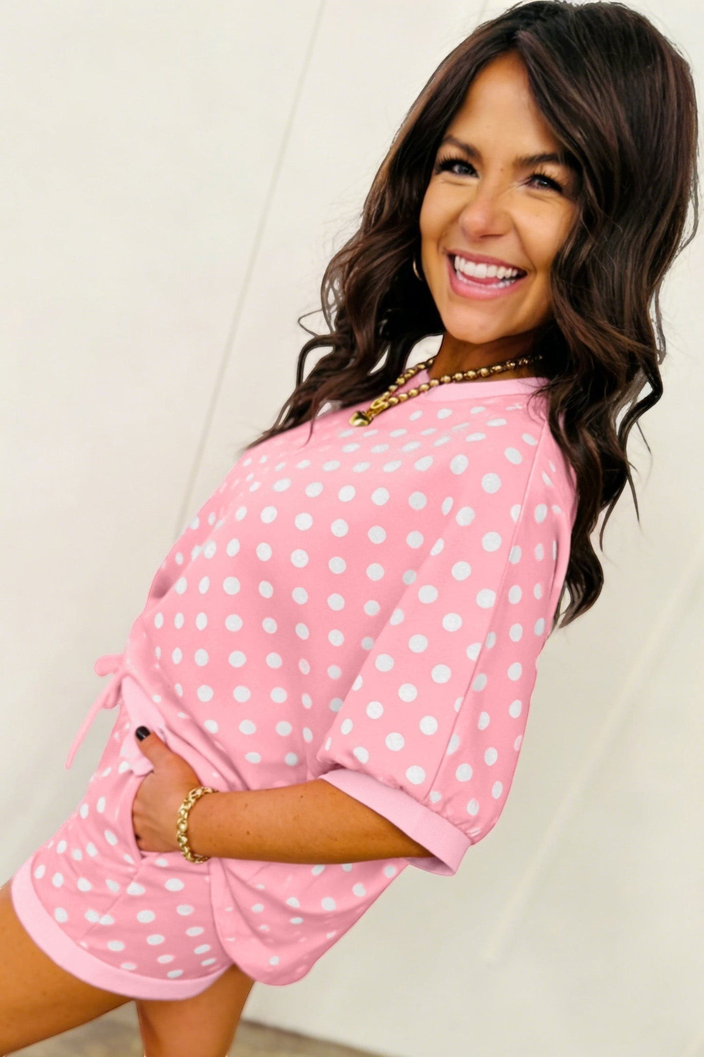 Doodlations Coffee Bar & Boutique pink polka dot lounge set with short sleeves and drawstring shorts on a smiling model