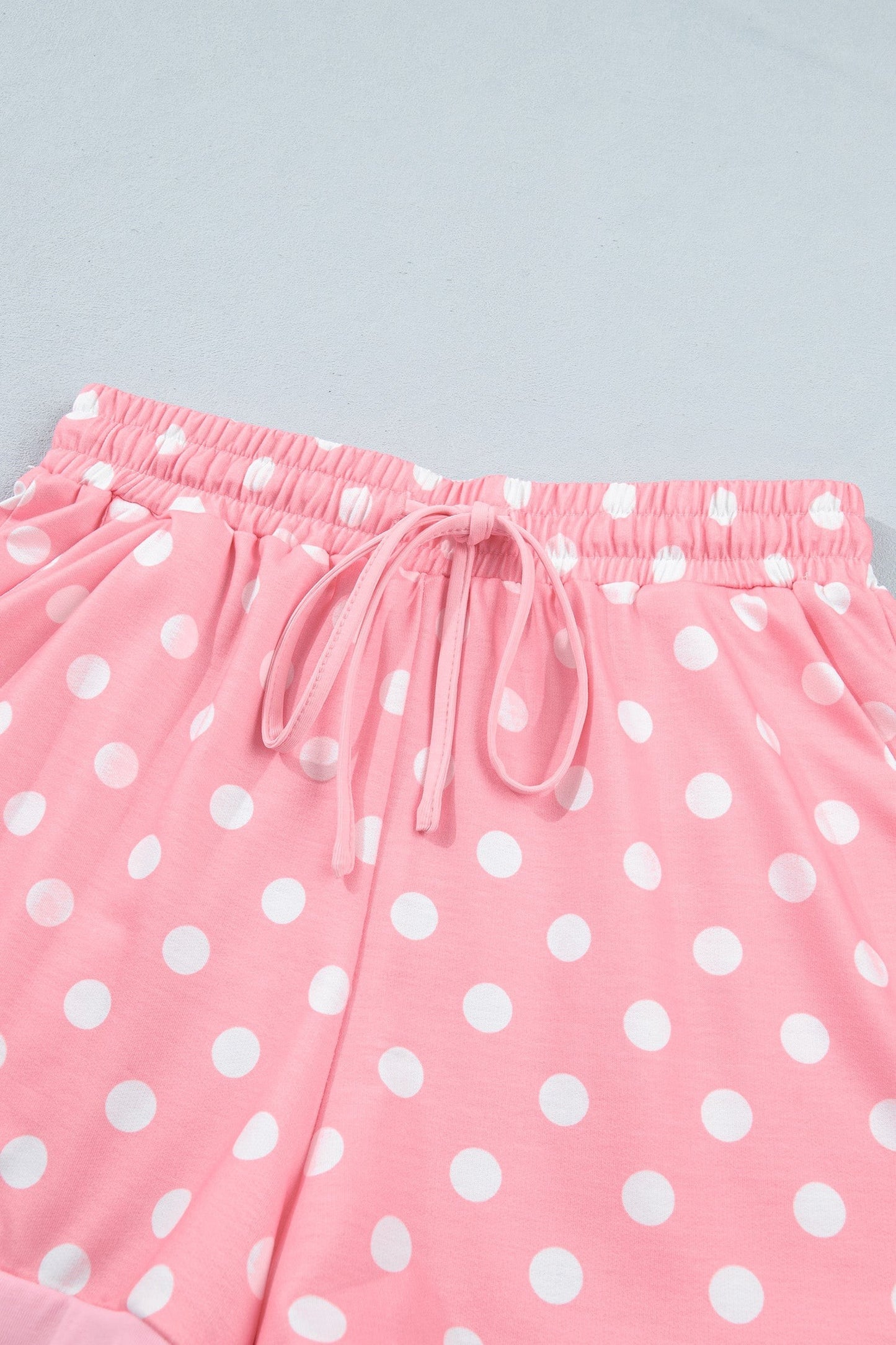Doodlations Coffee Bar & Boutique pink lounge shorts with white polka dots, elastic drawstring waist, and side pockets.