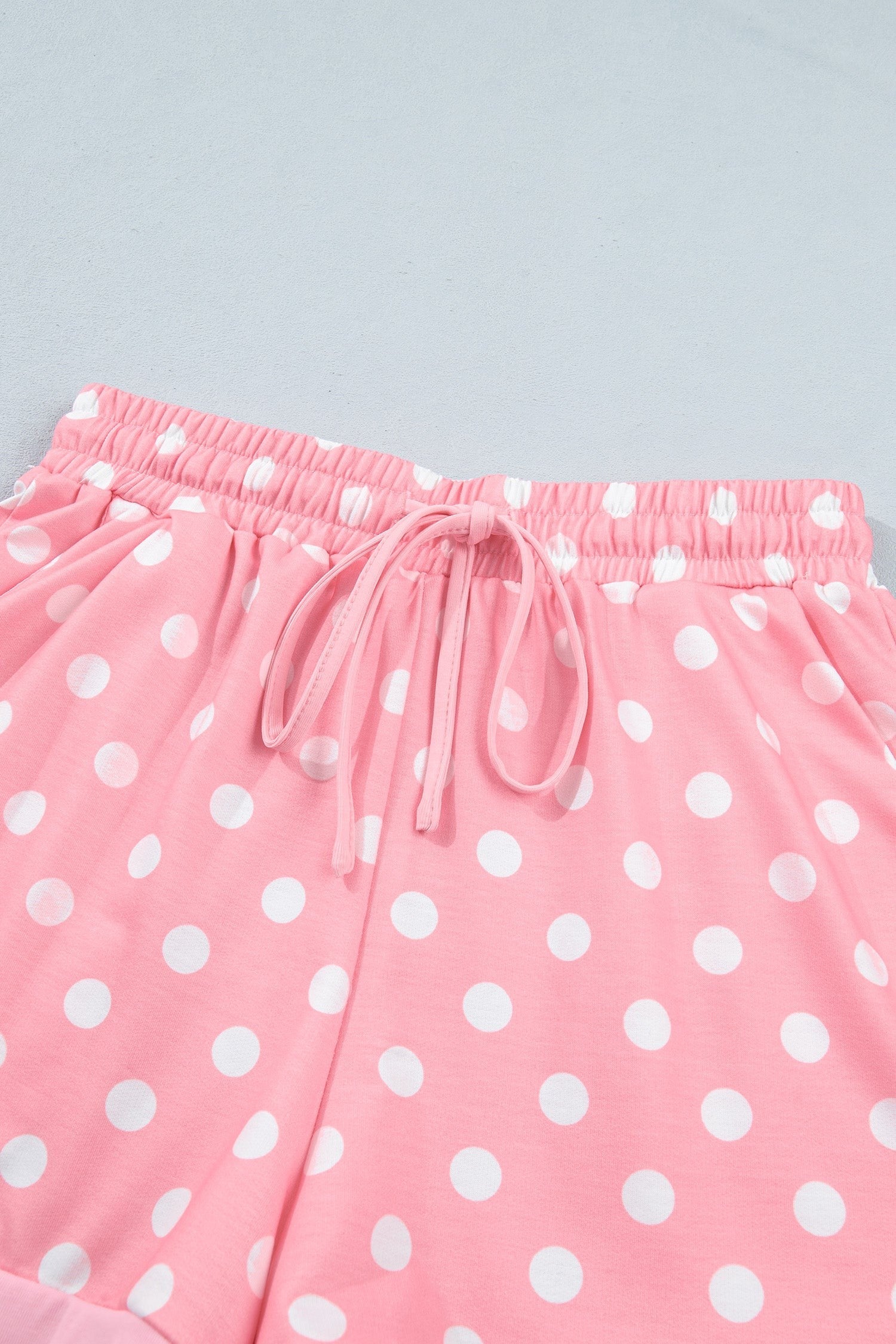 Doodlations Coffee Bar & Boutique pink lounge shorts with white polka dots, elastic drawstring waist, and side pockets.