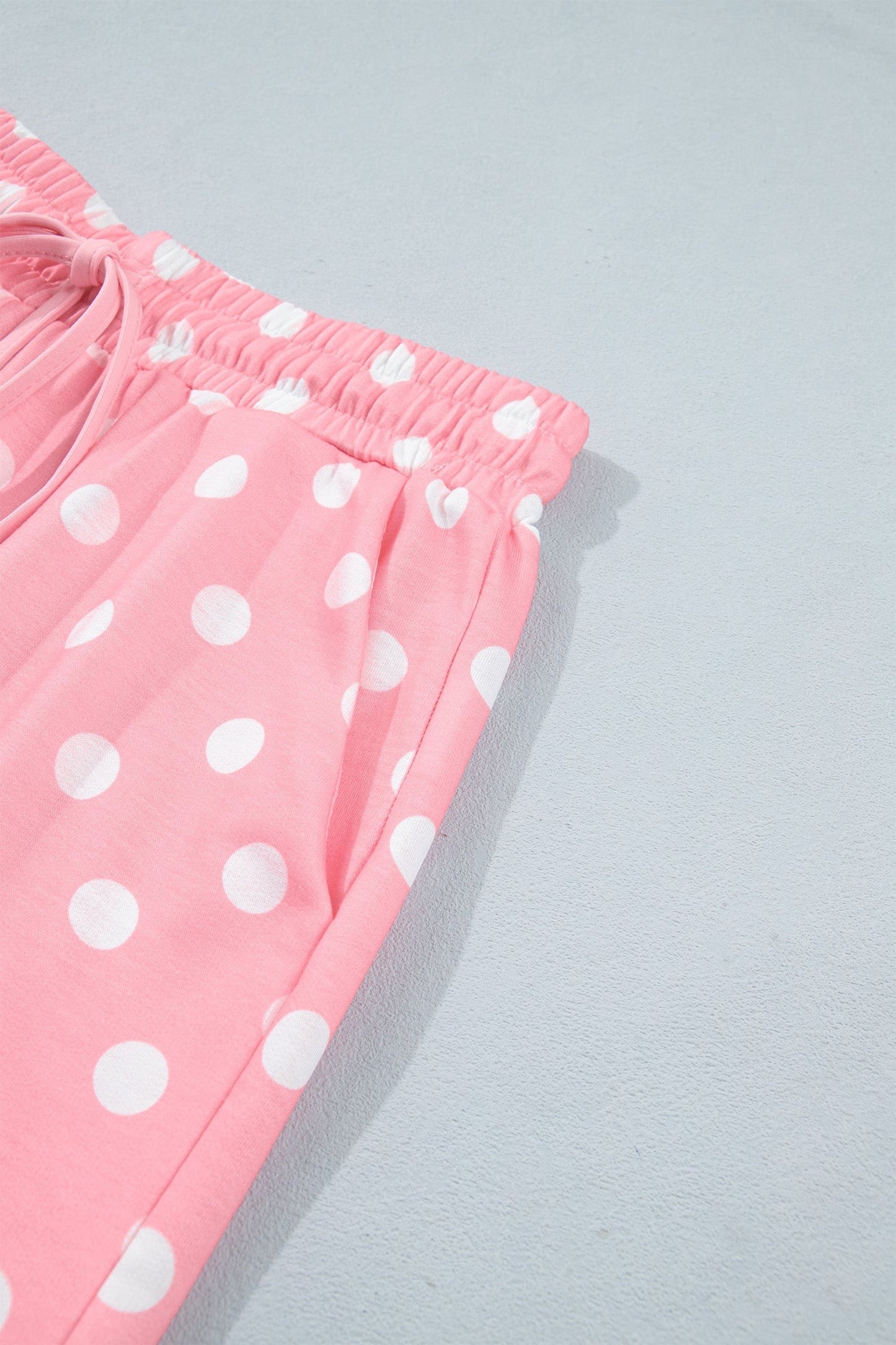 Doodlations Coffee Bar & Boutique pink lounge shorts with white polka dots, elastic drawstring waist, and side pockets.