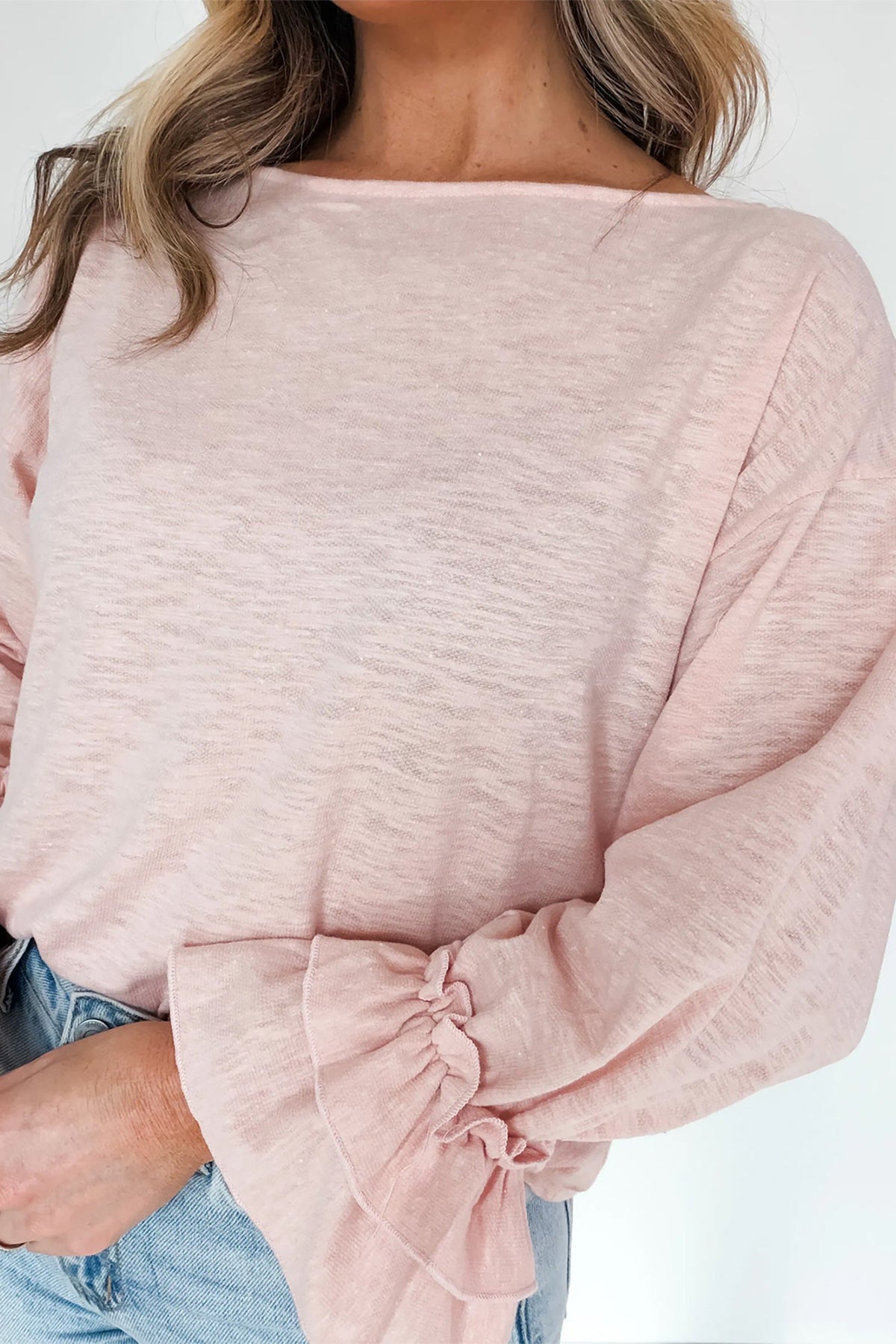 Doodlations Coffee Bar & Boutique baby pink long sleeve top with delicate ruffle cuffs and a soft textured fabric.