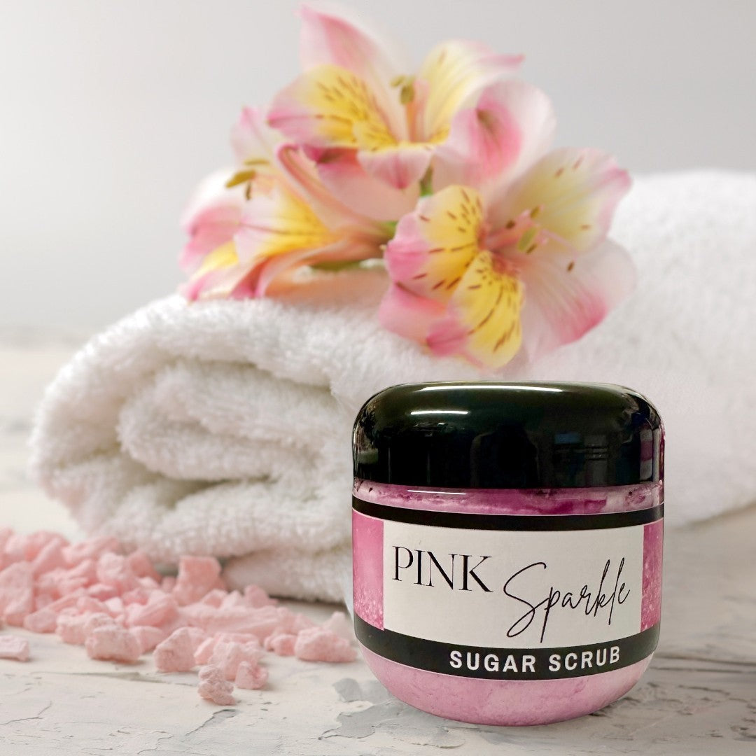 Doodlations Pink Sparkle Sugar Scrub, a luxurious exfoliating body scrub in a clear jar with a black lid. The scrub is pink and shimmery, with a label that reads "PINK Sparkle SUGAR SCRUB".
