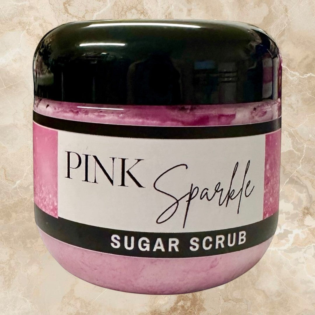 Doodlations Pink Sparkle Sugar Scrub, a luxurious exfoliating body scrub in a clear jar with a black lid. Pink scrub with fine sugar crystals.