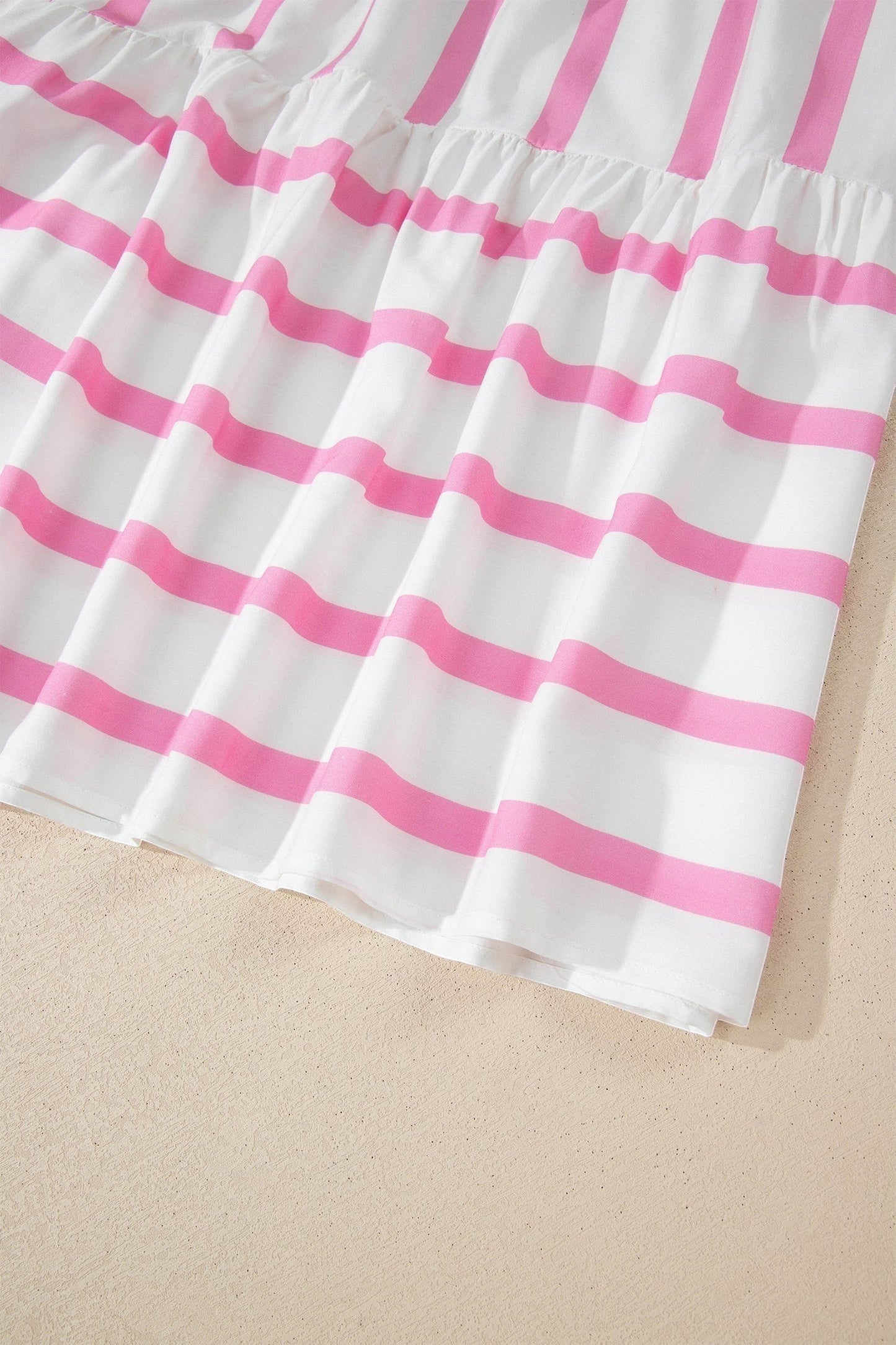 Doodlations Coffee Bar & Boutique white and pink striped tunic with V-neck and puffed sleeves.