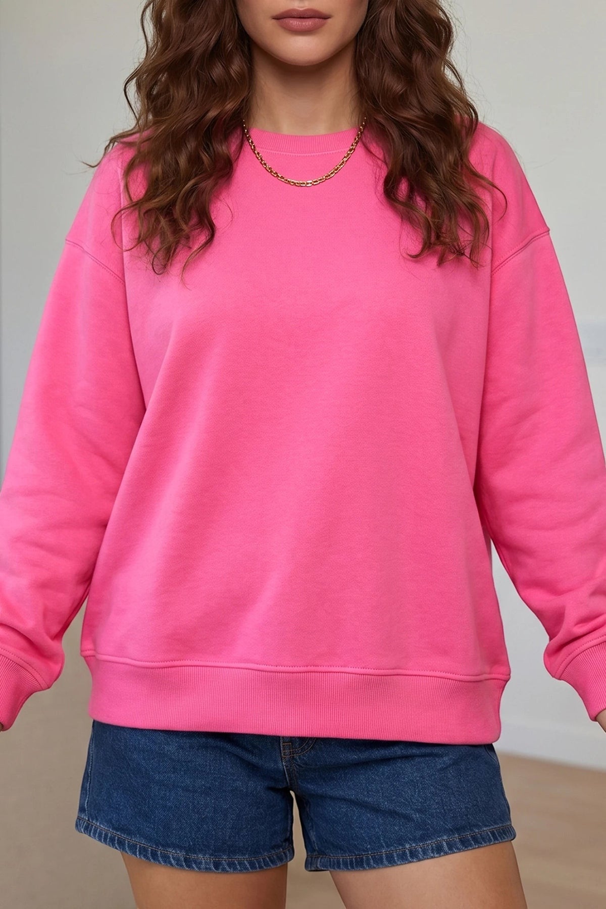 A woman wearing a Doodlations Coffee Bar & Boutique sachet pink long sleeve sweatshirt with a round neck.